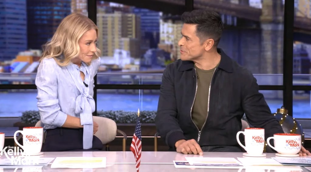 Kelly Ripa in blue blouse sat with Mark Consuelos in live studio