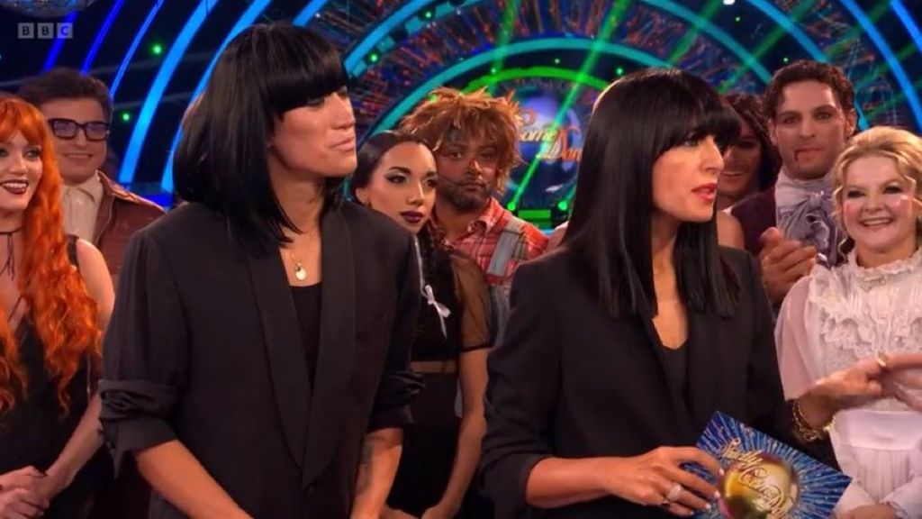 Carlos Gu dressed as Claudia Winkleman standing behind Claudia Winkleman