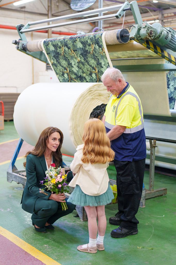 kate crouching talking to little girl and print works worker