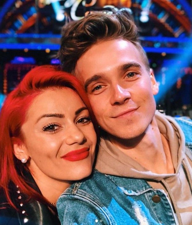 Dianne Buswell and Joe Sugg smiling with their heads close together on the set of Strictly
