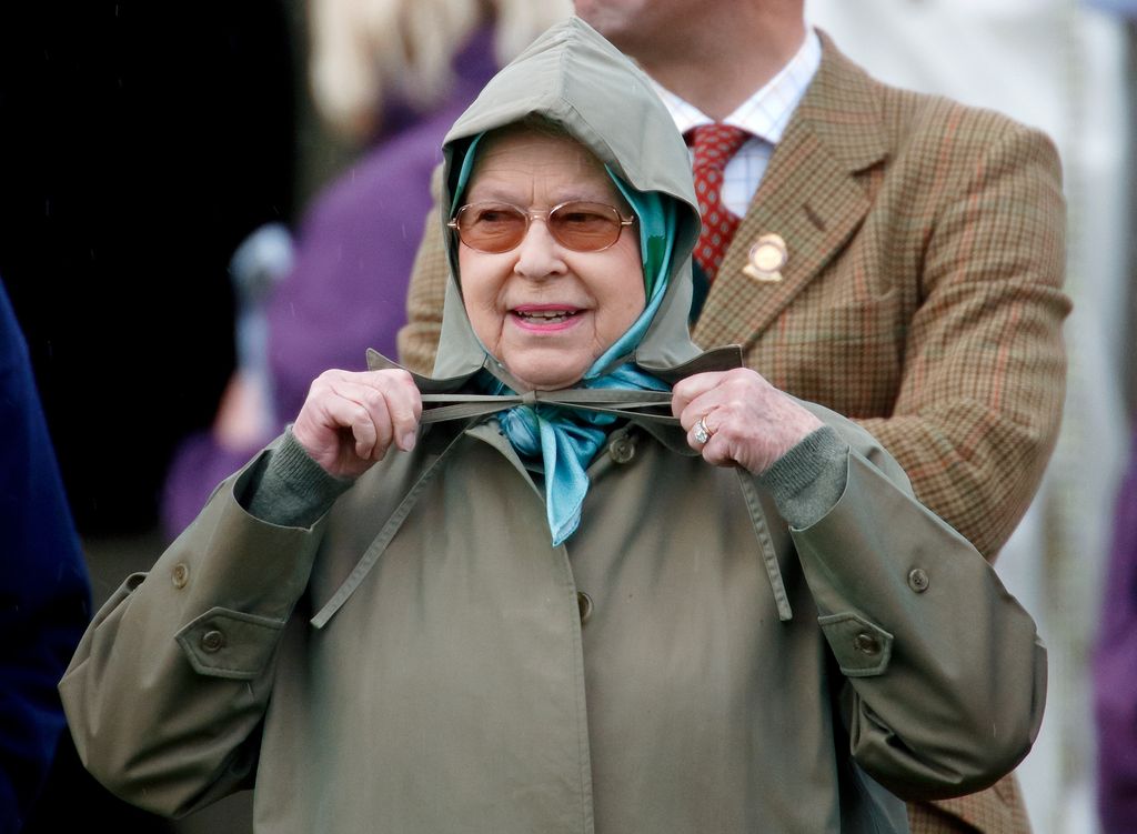 Queen Elizabeth tying knot in his raincoat
