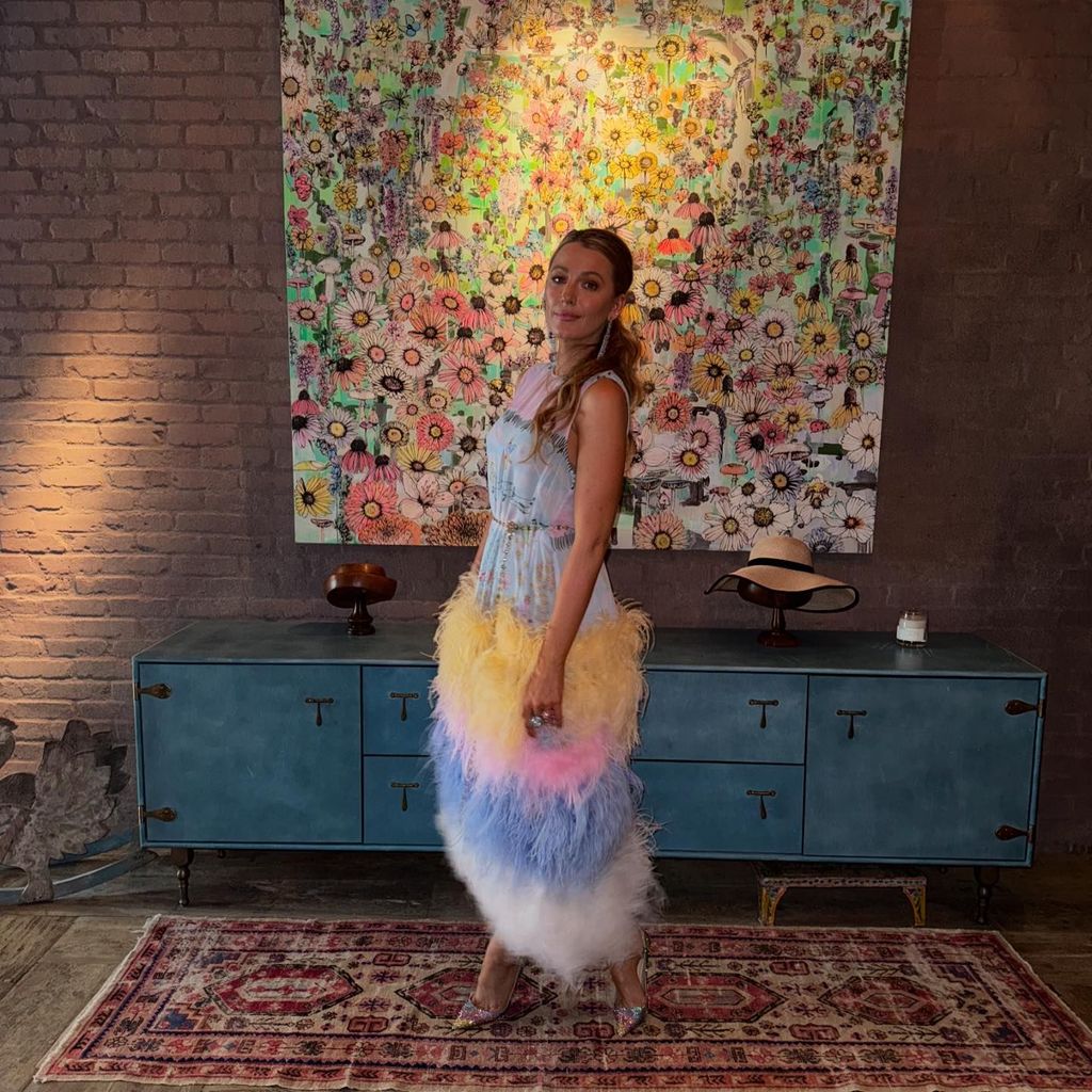 blake lively in entryway with bare brick with bright artwork