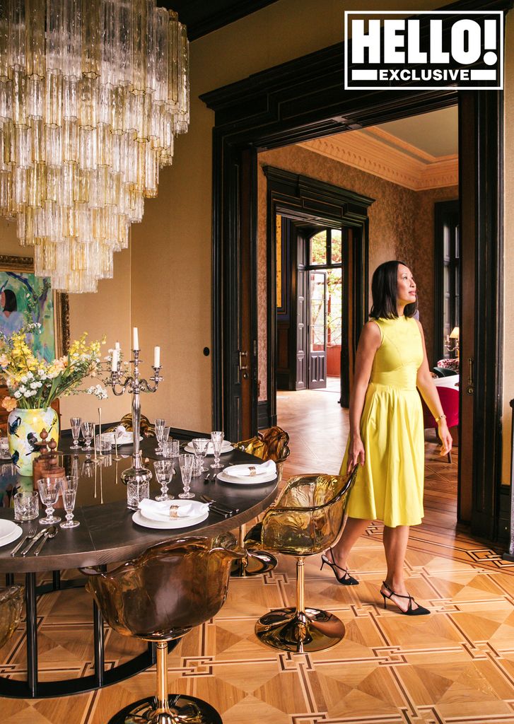 Woman next to a round dining table and chandelier