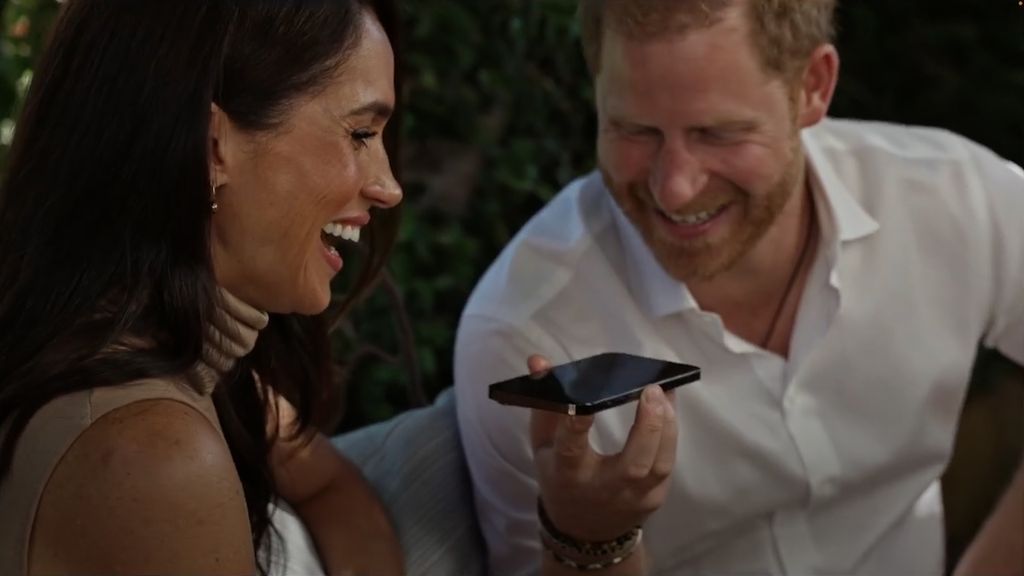 Close-up of Harry and Meghan talking into a phone on loud speaker