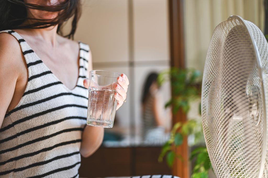 Close up of a woman holding glass of water.