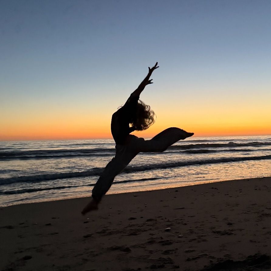 Rio Hudson leaping into air in front of sunset sea
