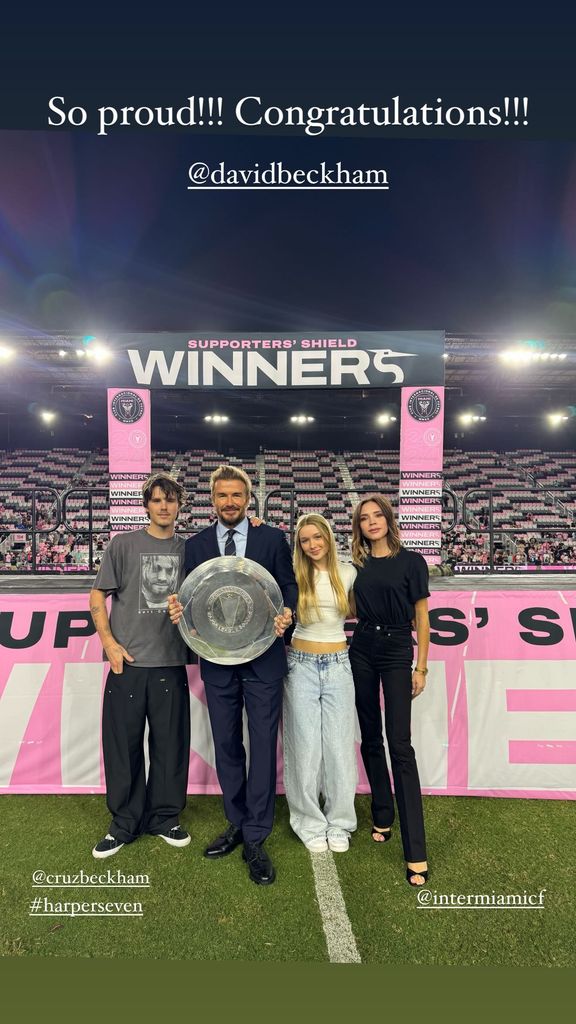 Cruz, David, Harper and Victoria Beckham posing on a football pitch