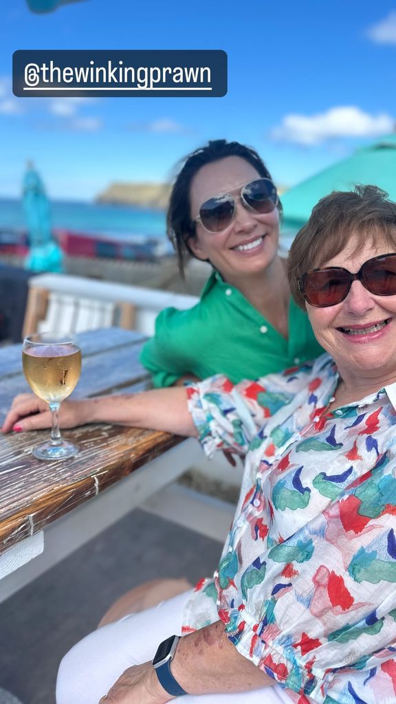 two women sat outside at table 