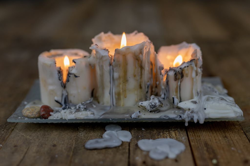 Old candles with dirty wax on a wooden table