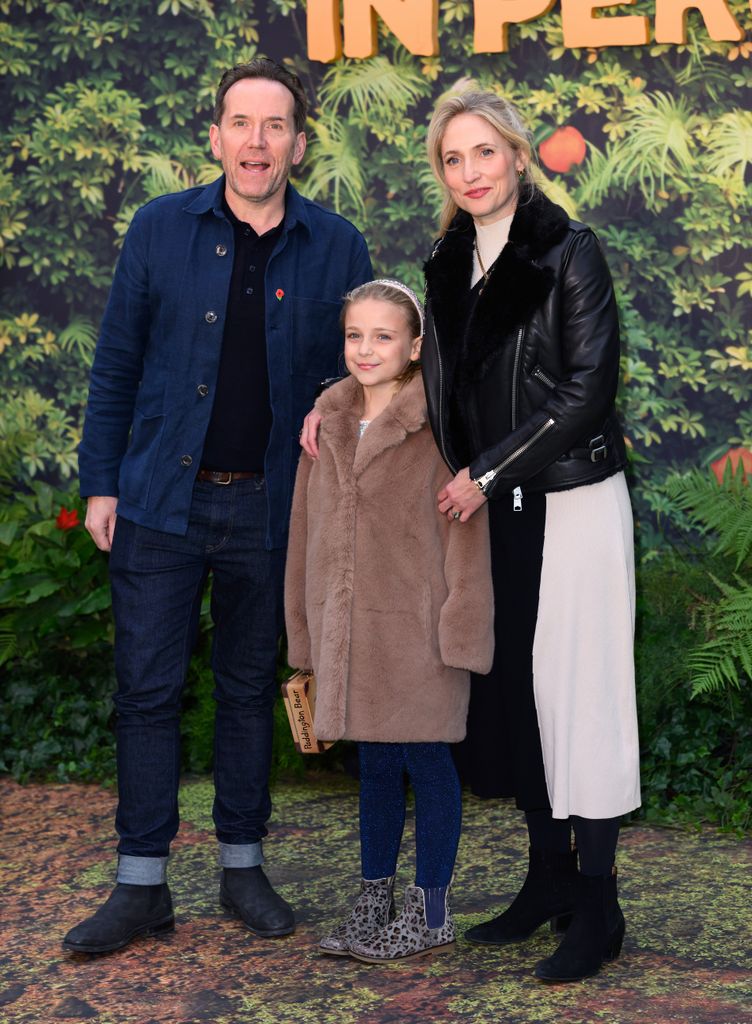 Ben Miller and his wife Jessica stand together and put their arms around their daughter, Lana, at film premiere