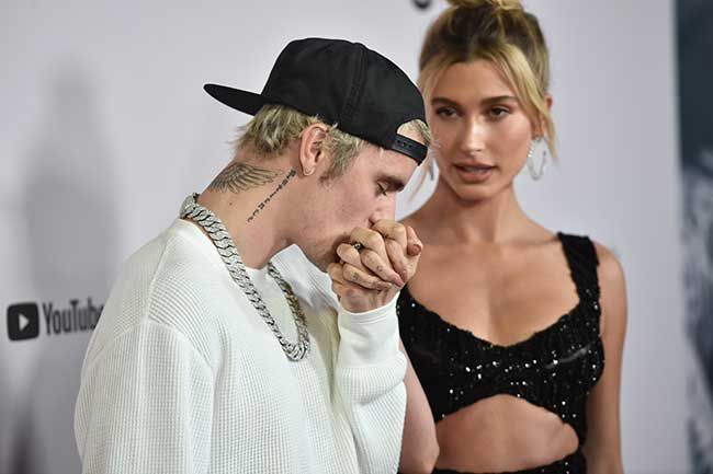 Justin Bieber kissing Hailey Biebers hand on a red carpet