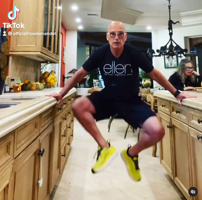 howie lifts himself off his feet using two large wooden kitchen counters for support and the kitchen is so large it continues for as far as the eye can see
