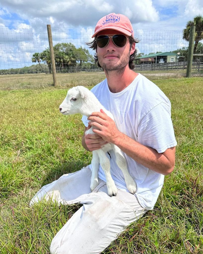 Oliver Oz holding a baby lamb
