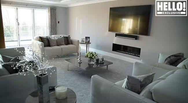 James and Ola Jordans former grey living room with plush sofas and tv on the wall 