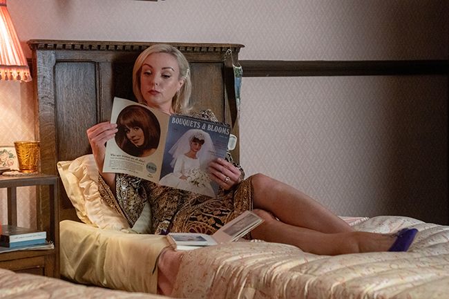 Helen George as Nurse Trixie reading a magazine on bed