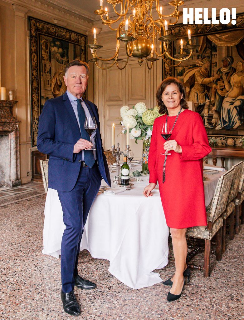 Miren and Nicolas each holding a glass of red wine from their estate in the dining room inside Château de Pennautier