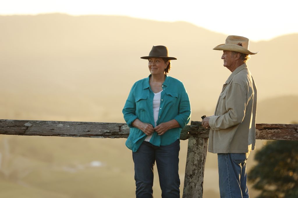 woman and man leaning on post