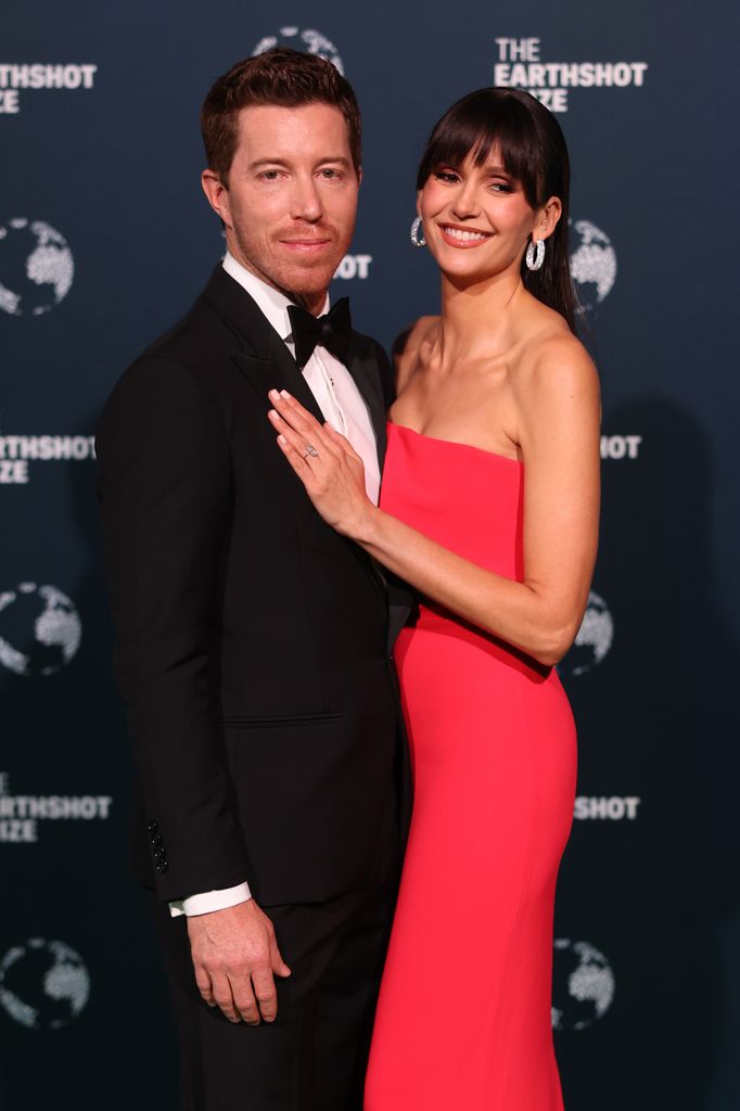 Shaun White in a black tuxedo and Nina Dobrev in a red dress