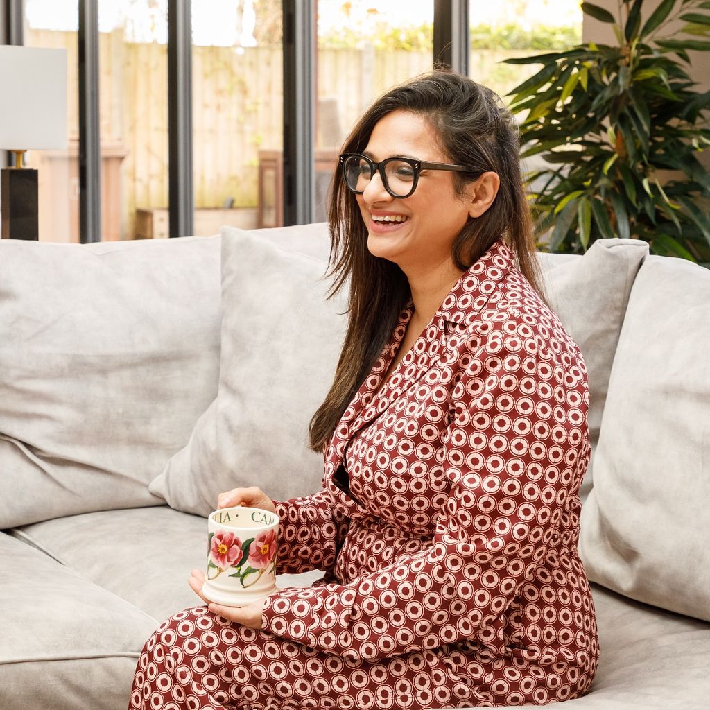 woman sitting in a print outfit with a cup of tea 