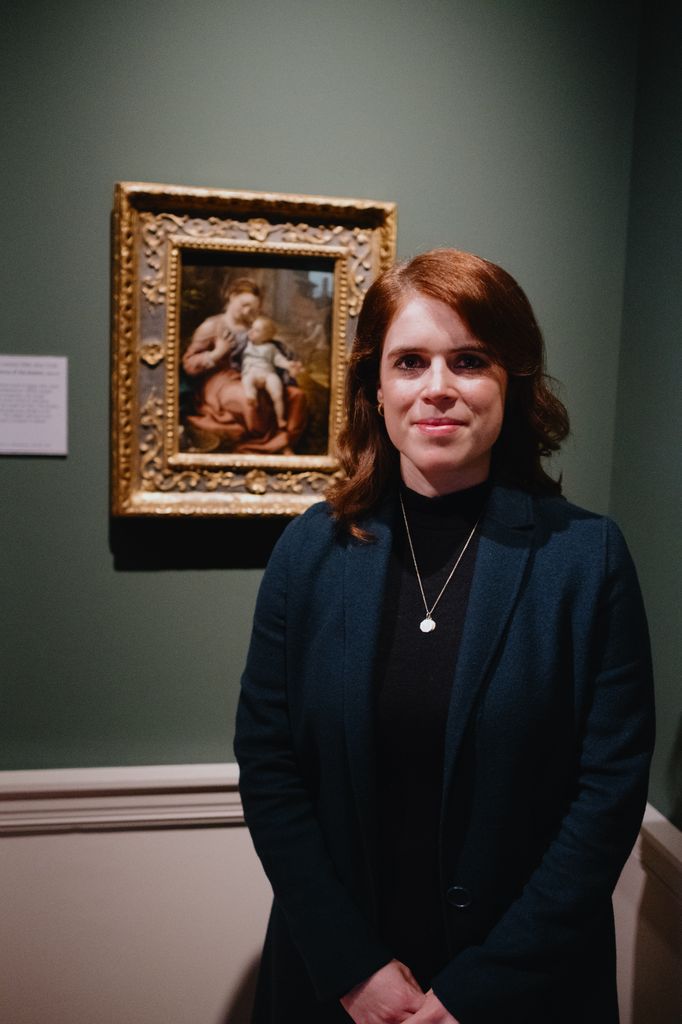 woman posing by painting in gallery 