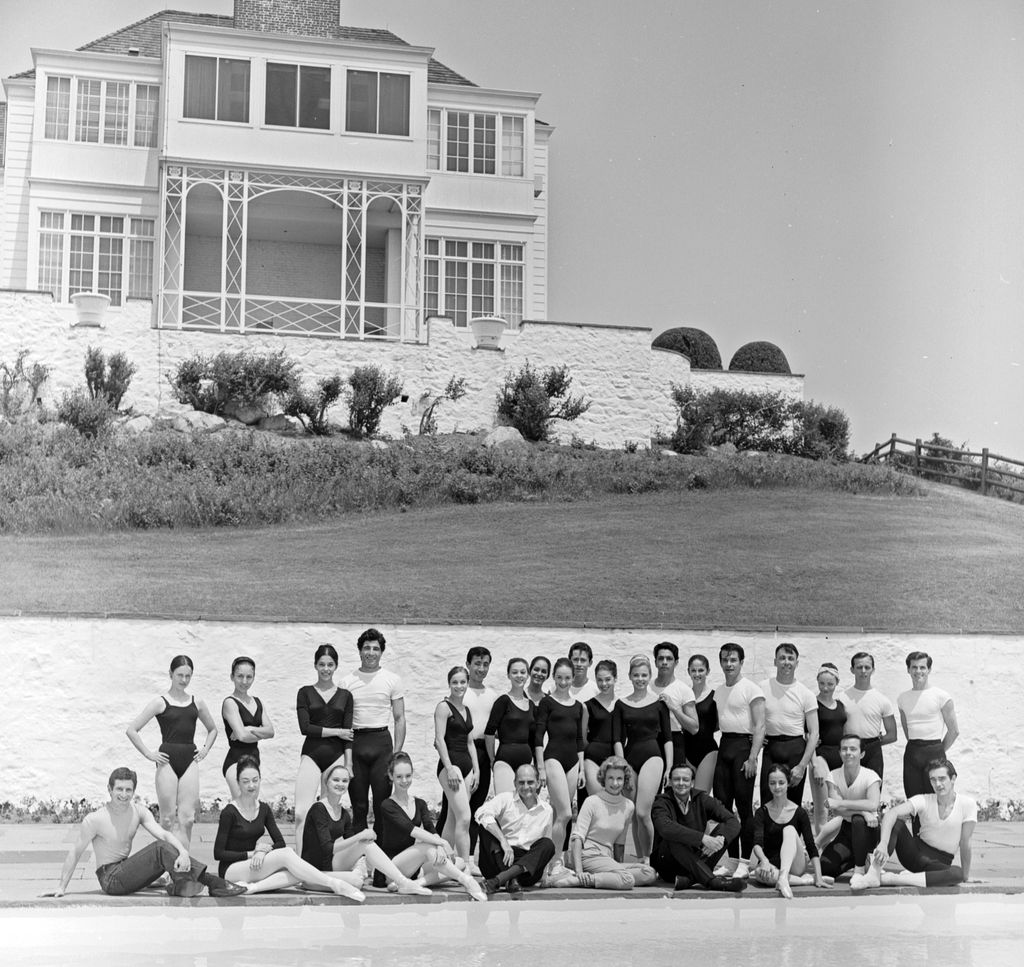 Rebekah Harkness (centre, seated, in white) and her Harkness Ballet Company photographed at her estate in Watch Hill, R.I., 1964
