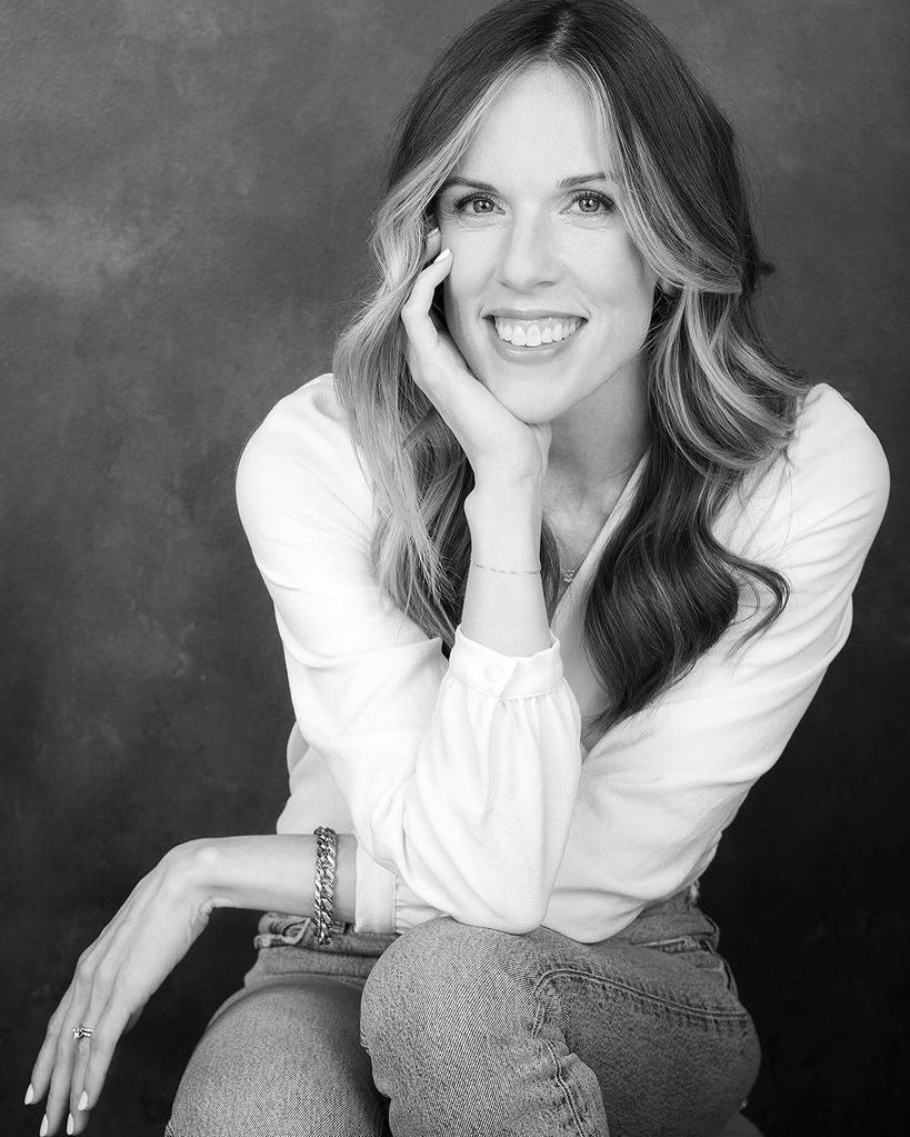 Woman smiling in black and white, wearing a white shirt 