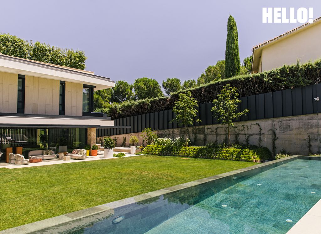 An outdoor swimming pool and dining area outside their three-storey, contemporary-style house