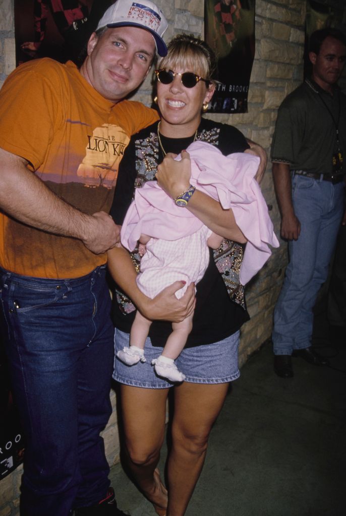 Garth Brook beside his wife Sandy Mahl holding their infant daughter in 1994