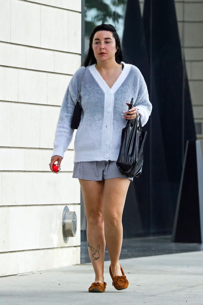 Amanda Bynes walking in LA in a grey cardigan and a short skirt