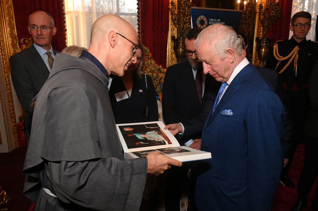 King Charles looking inside a photo book