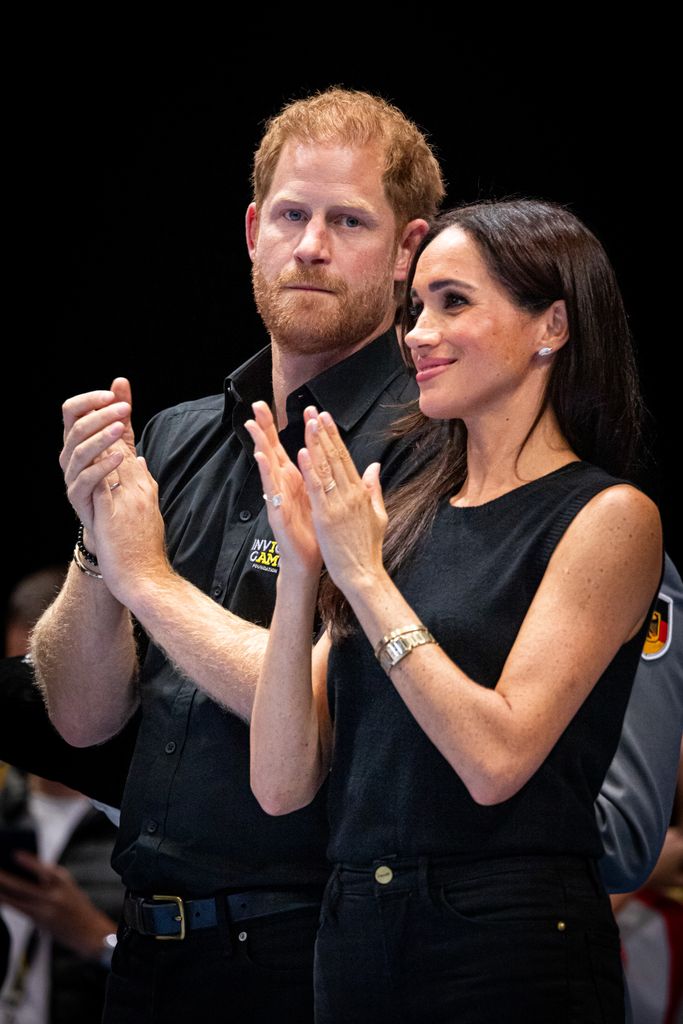 Prince Harry, Duke of Sussex and Meghan clapping in black outfits