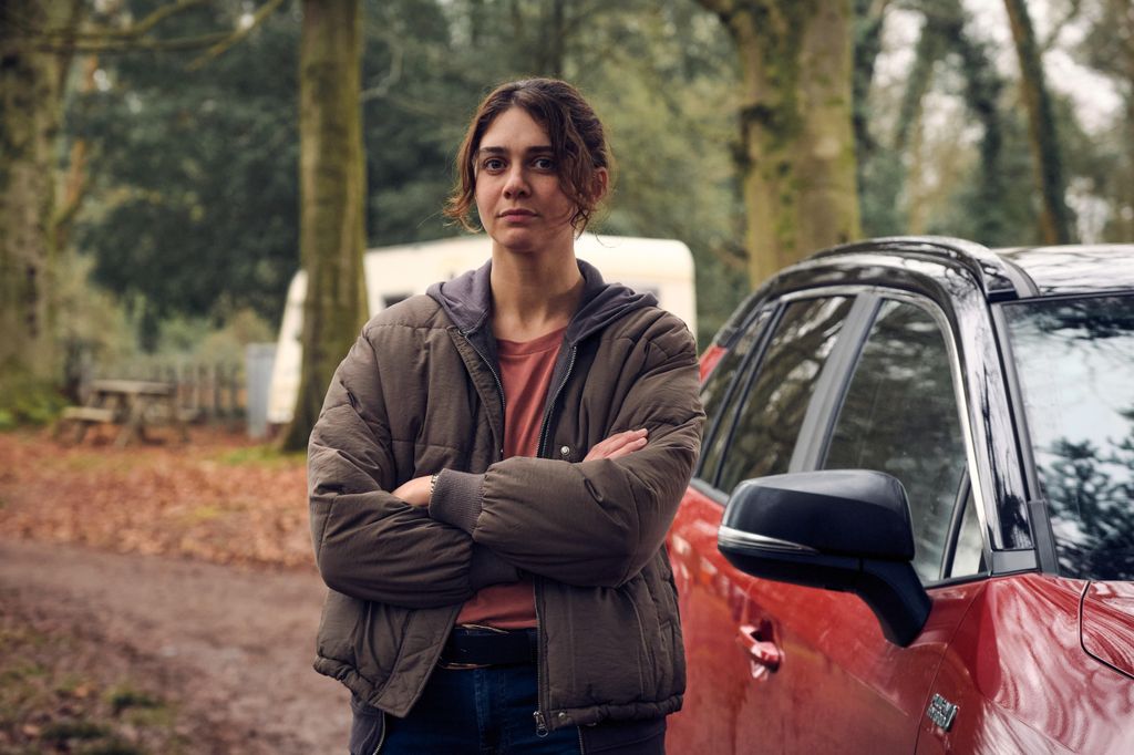 woman standing next to car in woods