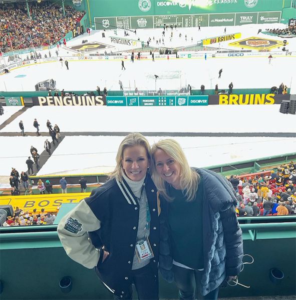 Jennifer Ashton embracing a friend at an ice hockey match