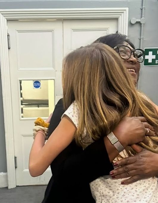 A young girl hugging a midwife