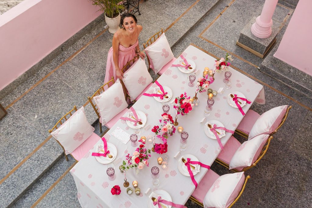 Rosanna Falconer in Jaipur next to tablescape on pink terrace