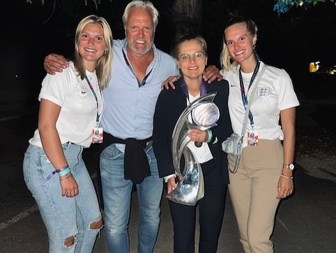 Sarina Wiegman holding a trophy with her husband and two daughters