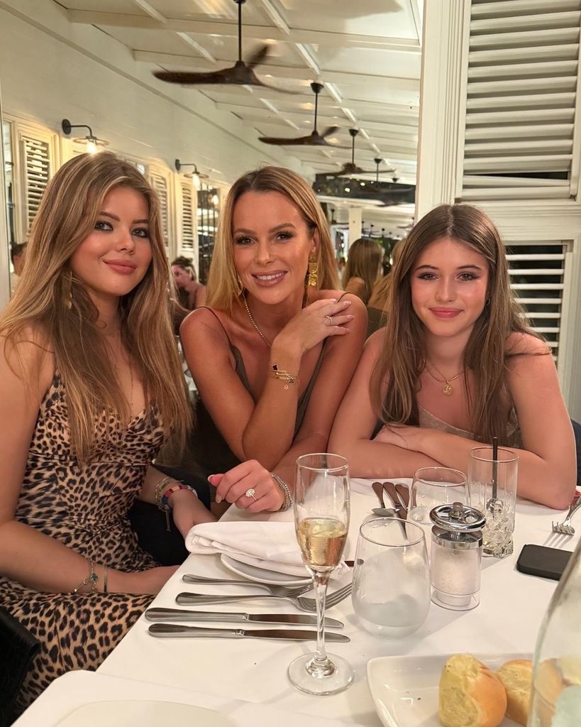 A photo of Amanda Holden with her daughters Hollie and Lexi sitting at a dinner table on holiday