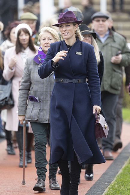 zara tindall in navy belted coat with purple accessories at cheltenham