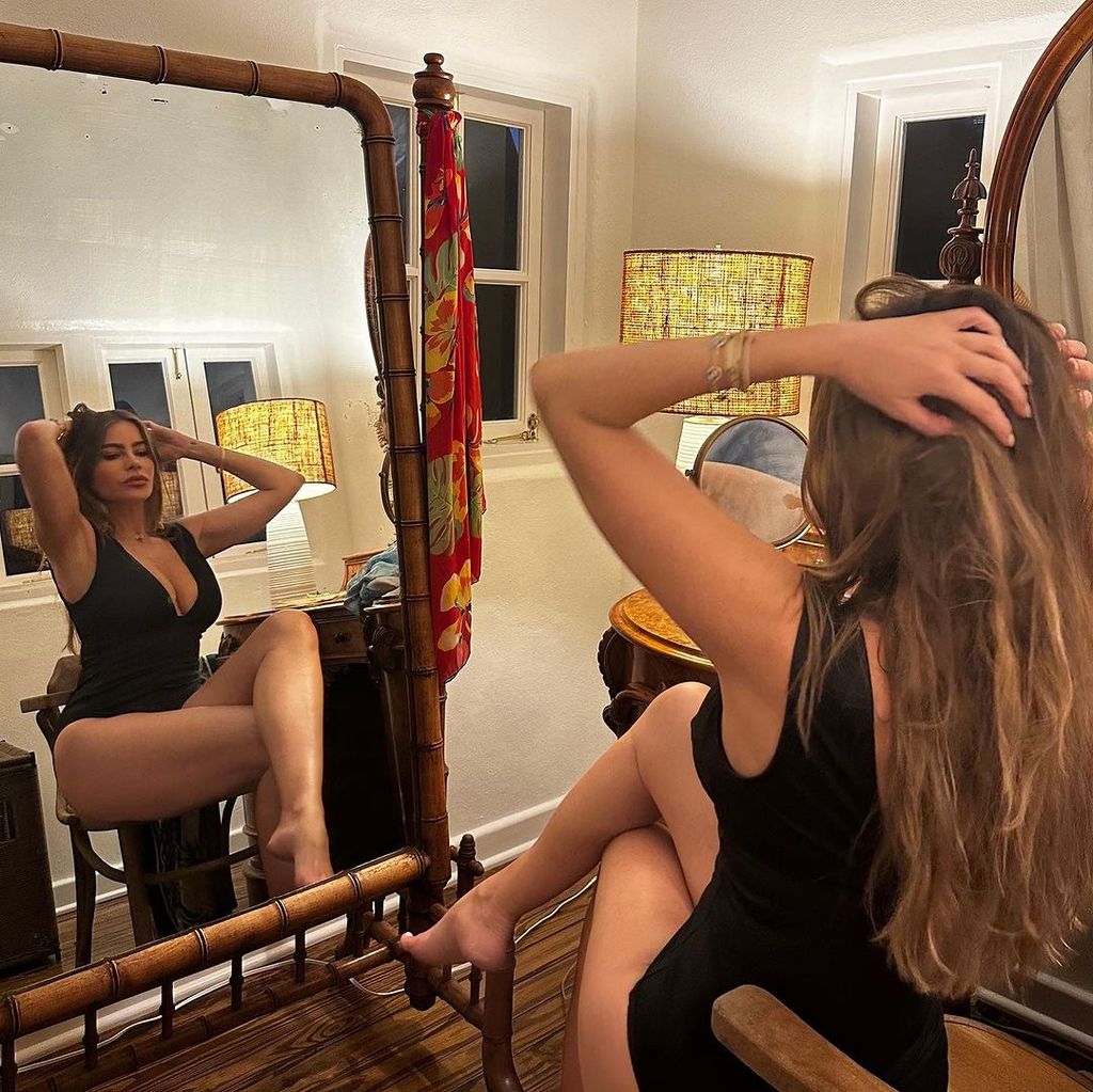 Sofia Vergara posing for a mirror photo in a black one-piece