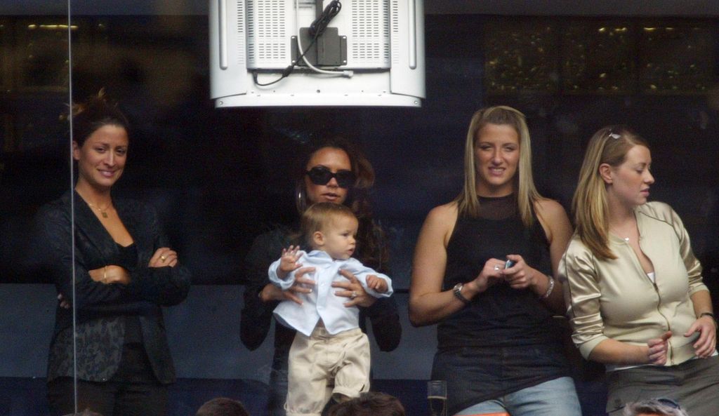 Victoria Beckham holds son Romeo beside David Beckham's PA Rebecca Loos (L) during the Spanish Primera Liga match between Real Madrid in 2003