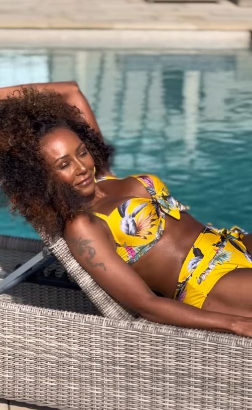 Mel B relaxing by the pool in a tropical-print bomb