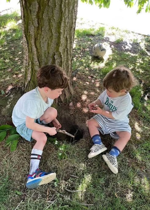 August and Ernest Brooksbank playing by a tree