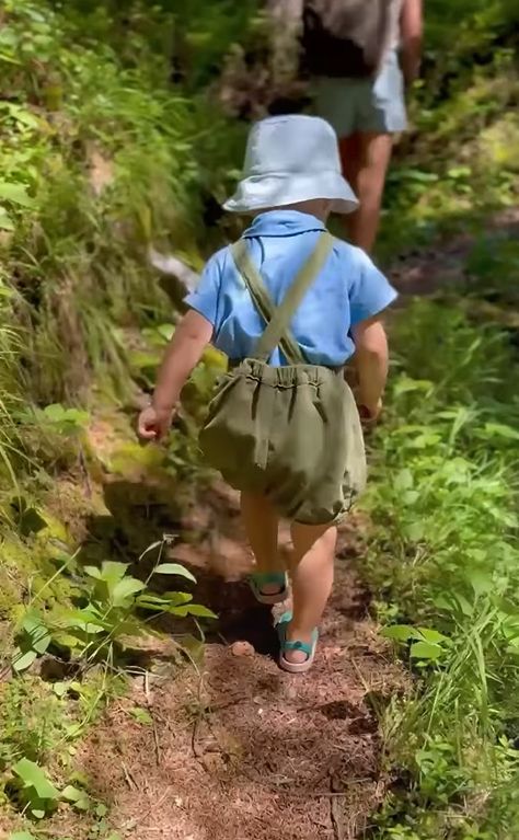 A young boy walking through a forest