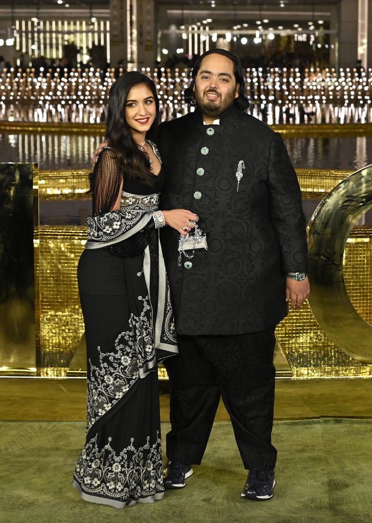 Anant Ambani in a black and white embroidered dress with Radhika Merchant