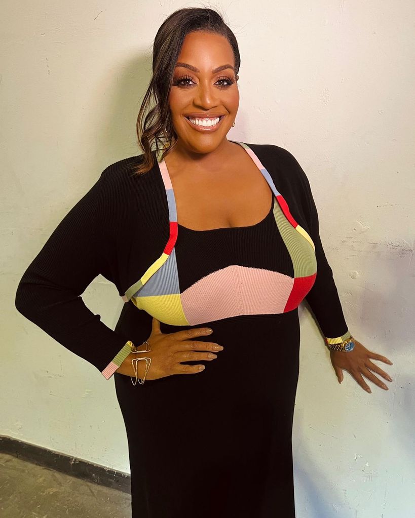 Alison Hammond smiles with her glossy hair tied into a neat, curled ponytail
