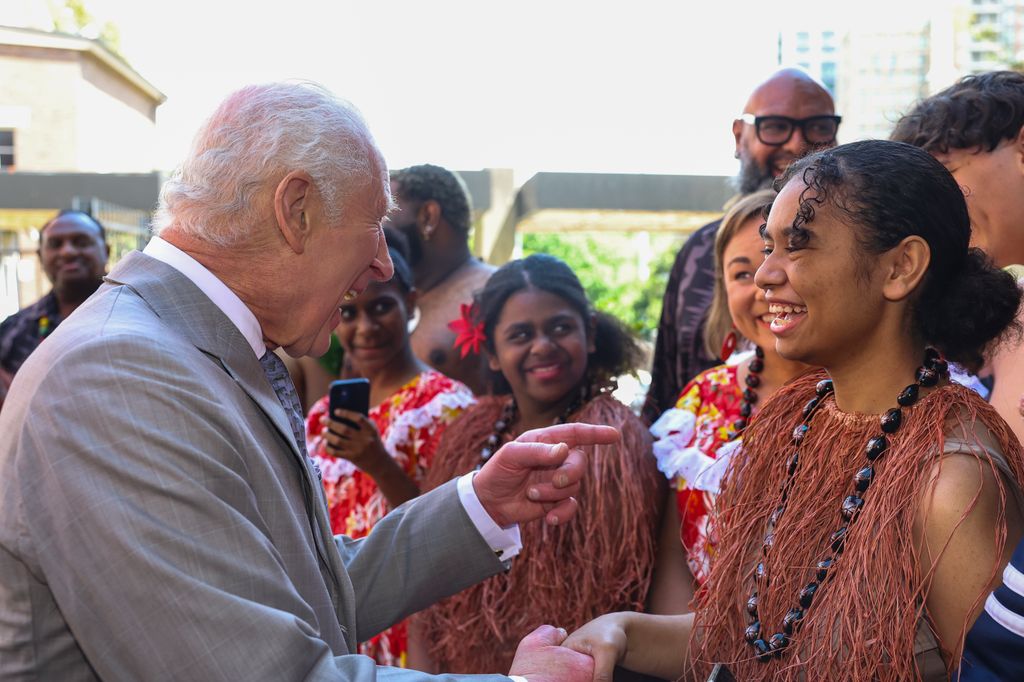 King Charles III greets a member of the Indigenous community during a visit to the National Centre for Indigenous Excellence