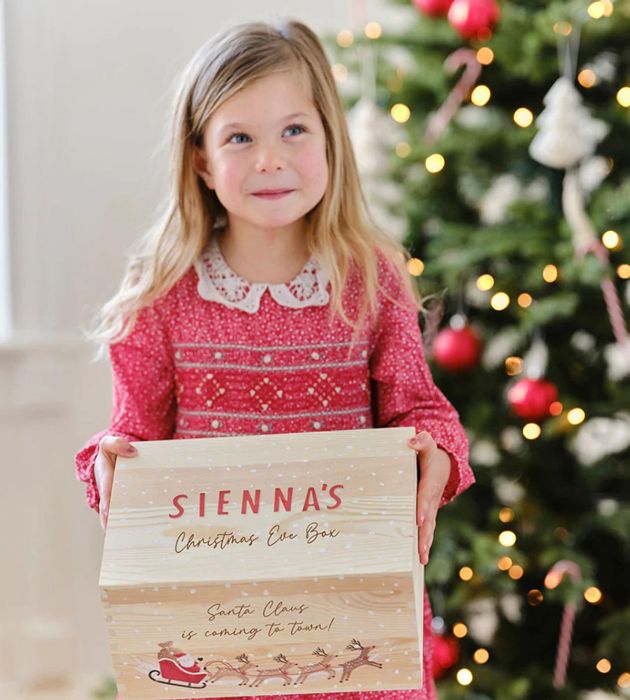 young girl holding christmas eve box