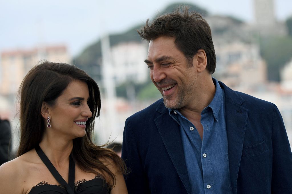 Penelope Cruz (L) and her husband Spanish actor Javier Bardem looking at each other smiling 
