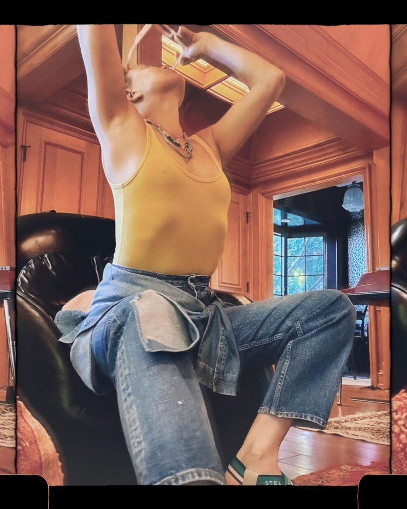 Kate Hudson stretching in a yellow vest