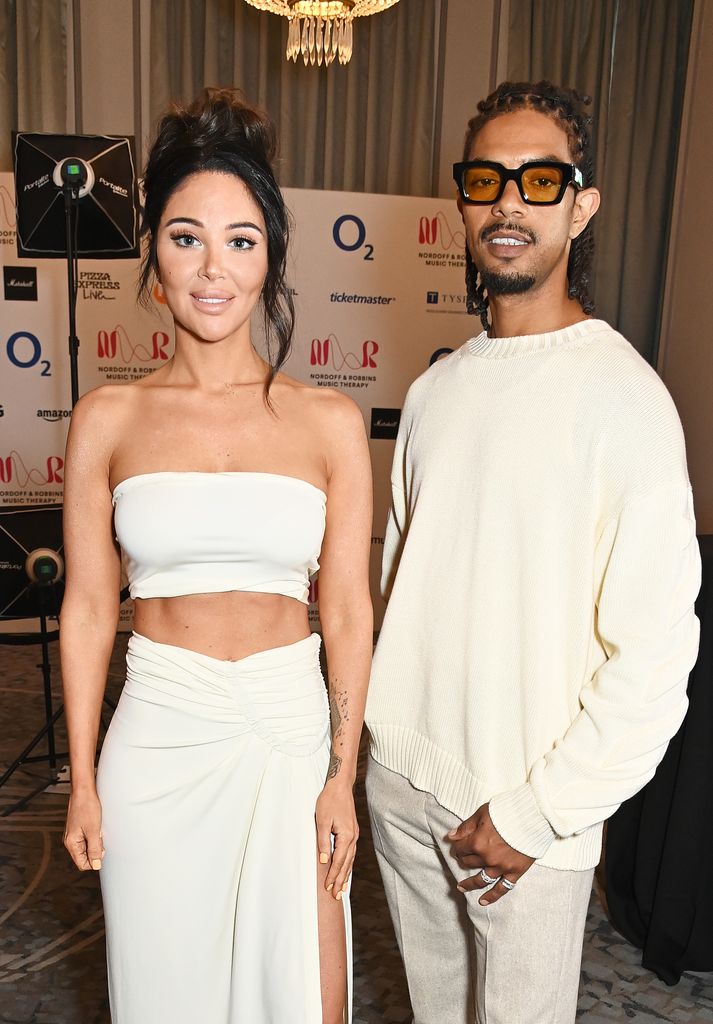 duo posing in hotel wearing white outfits